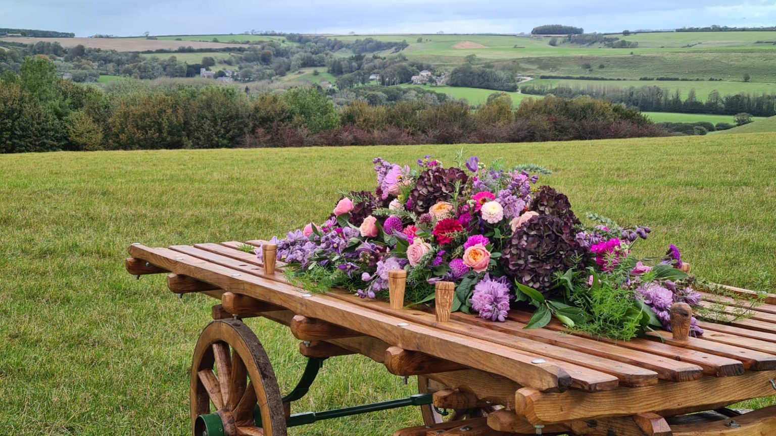 Boerenkar met een bloemstuk en wijd uitzicht over het landschap van Dorset Downs