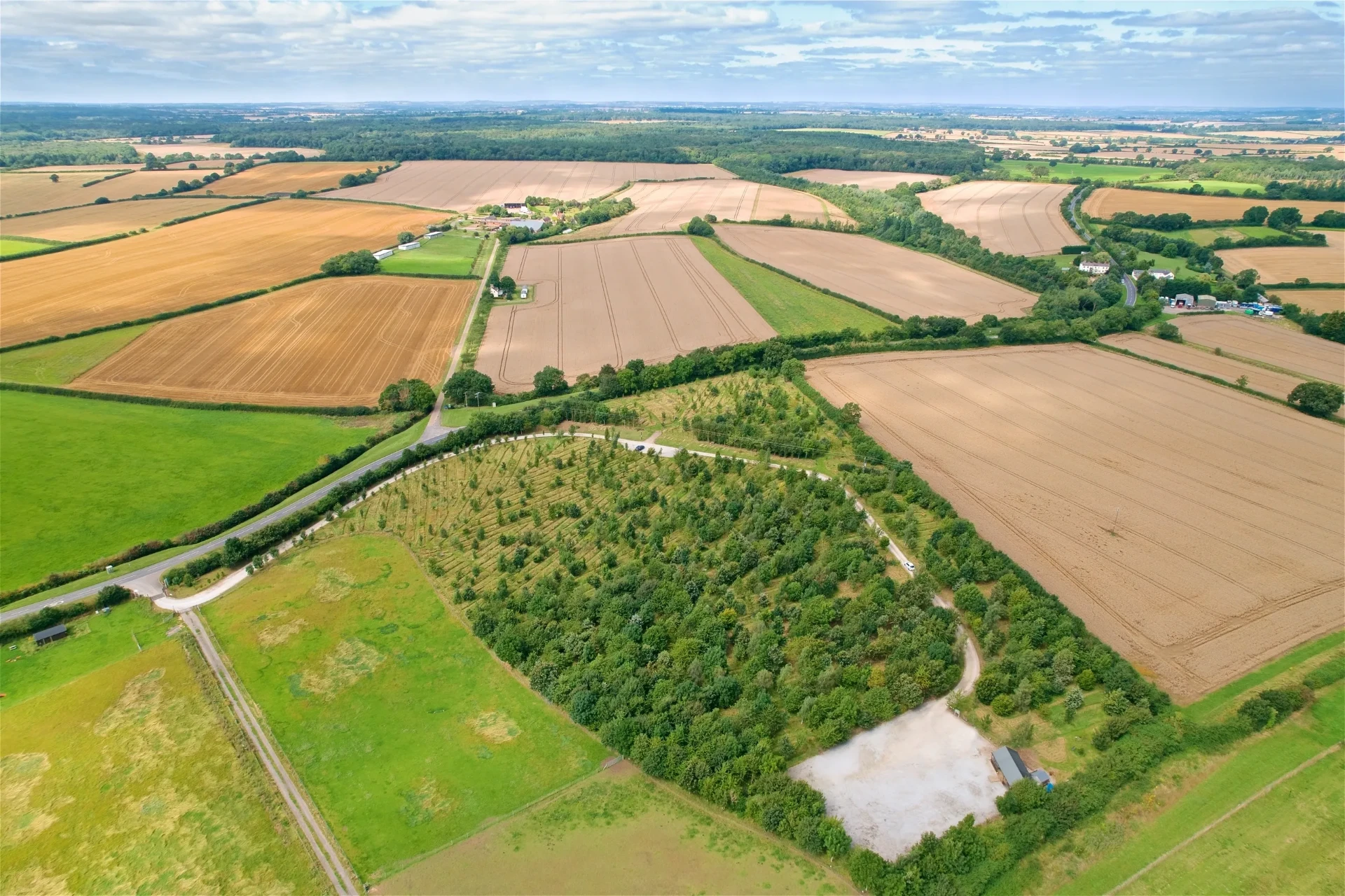 Luchtfoto van een perceel met jonge natuuraanplant midden in uitgestrekte landbouwgrond